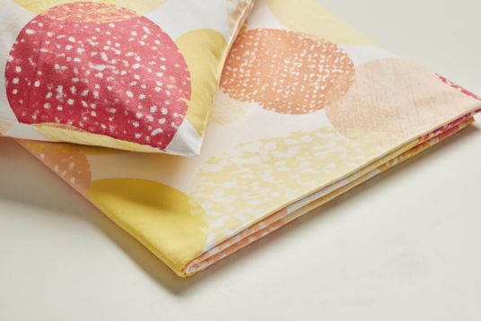 Bunt bedruckte Bettwäsche mit roten, orangen und gelben Kreisen auf weissem Grund