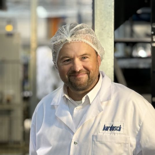 Produktionsleiter bei bardusch mit Haarnetz in der Wäscherei