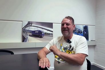Martin Breuer, Mitarbeiter von bardusch im Interview vor Wandbildern